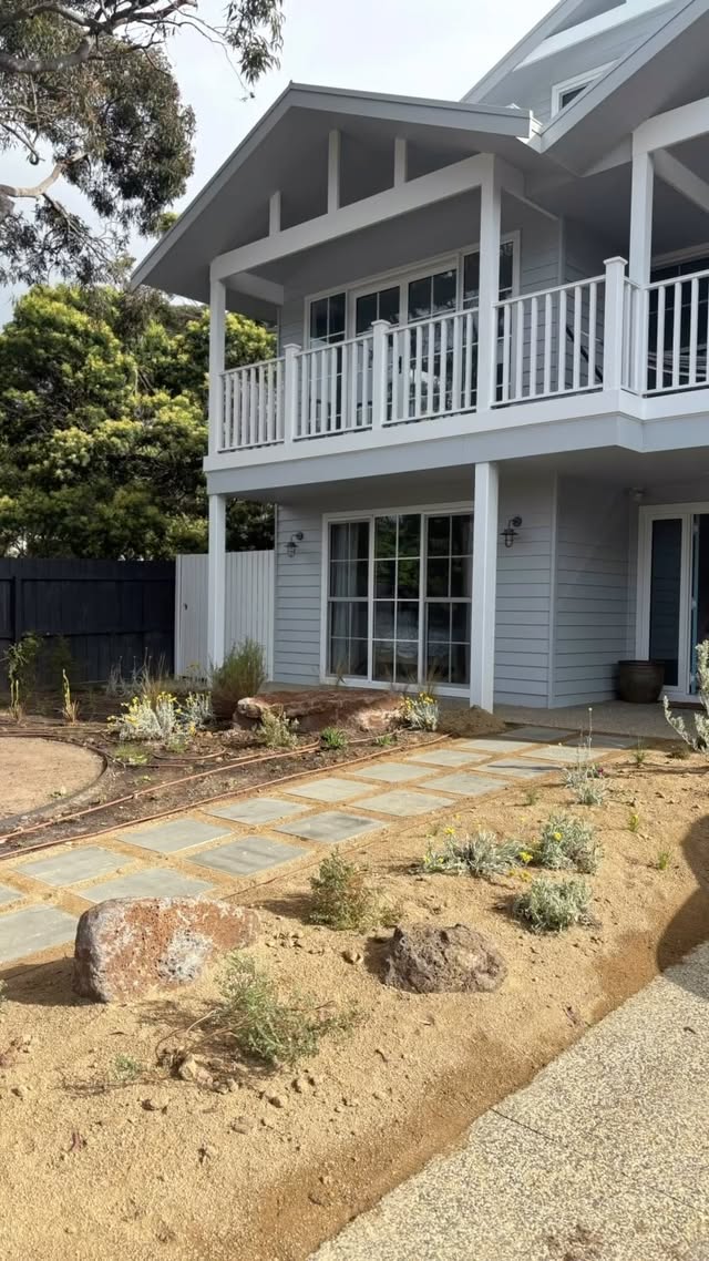 Completed Hampton style home with a balcony overlooking a landscaped garden