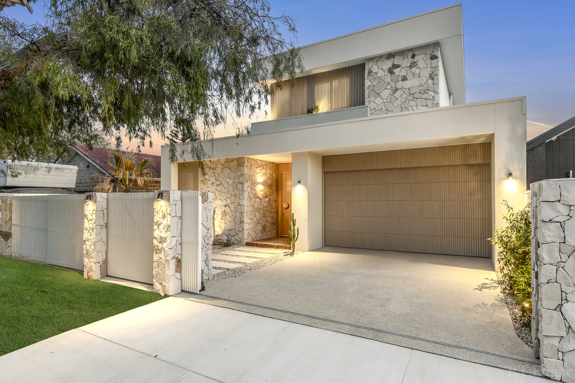 Contemporary Constructology home with a stone facade, timber detailing and an integrated garage