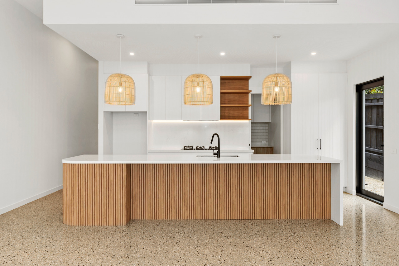 Halibut Avenue kitchen with sculpted timber joinery and a stone island