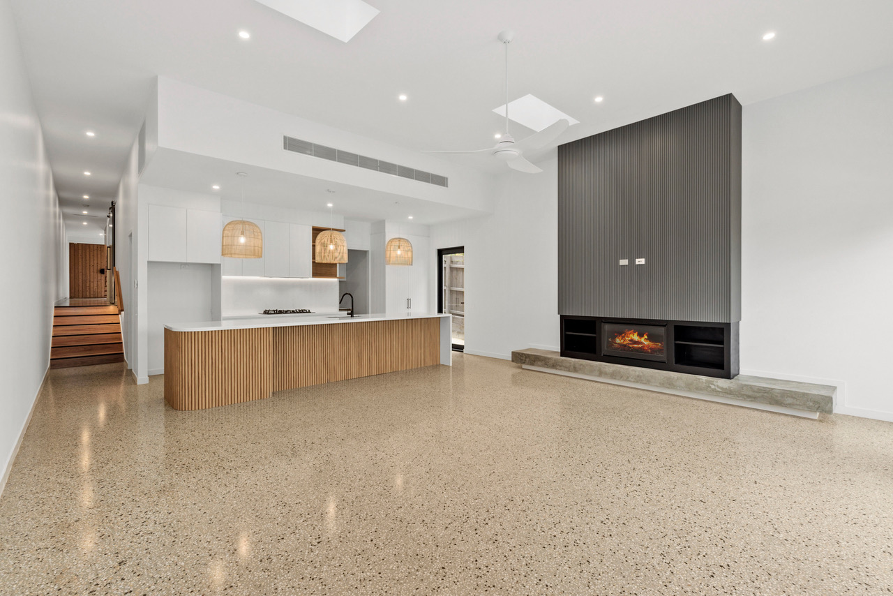 Halibut Avenue open living room with polished concrete and a fireplace