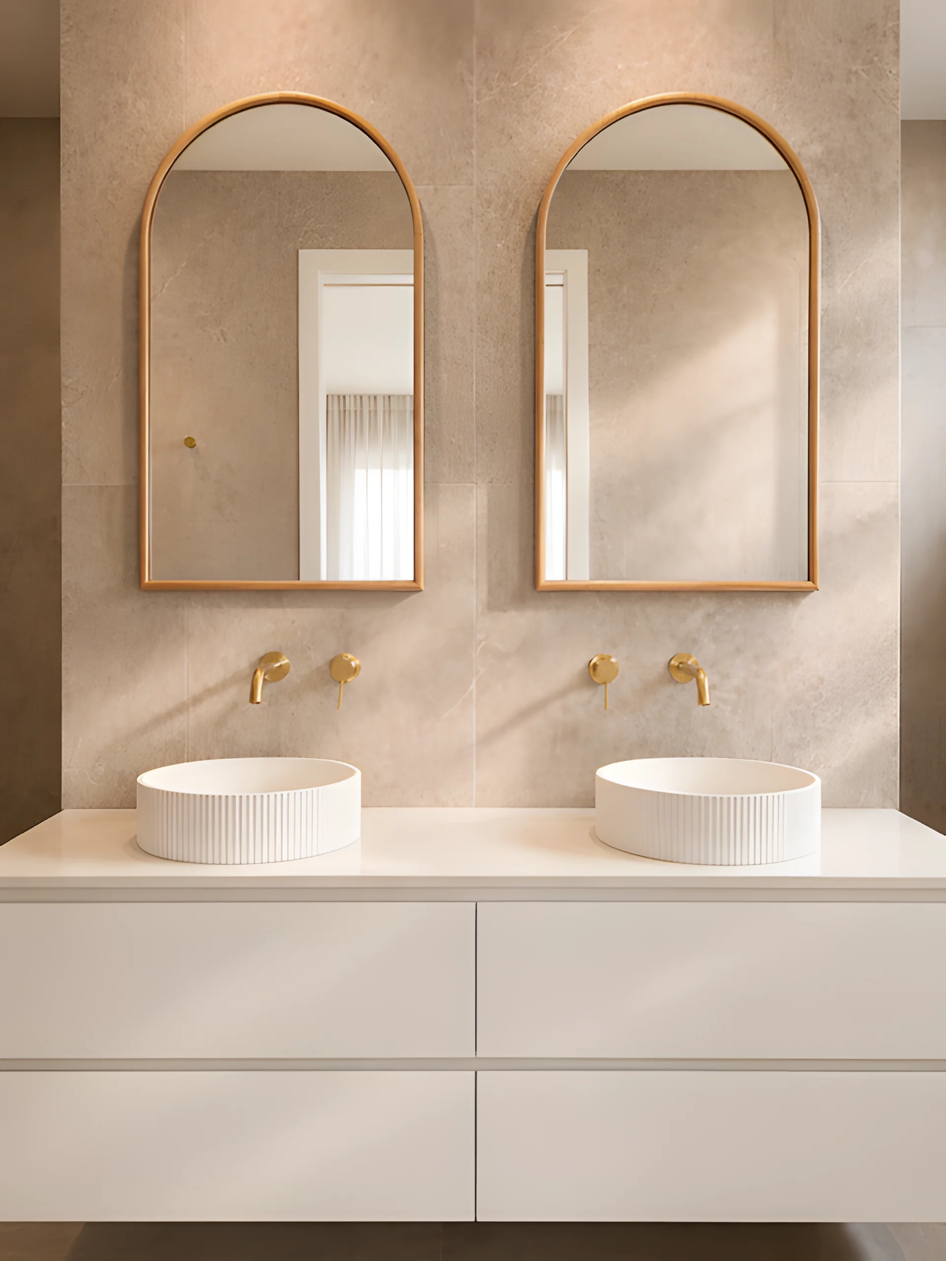 Coastal Boulevard ensuite with pale finishes, curved mirrors and warm timber details