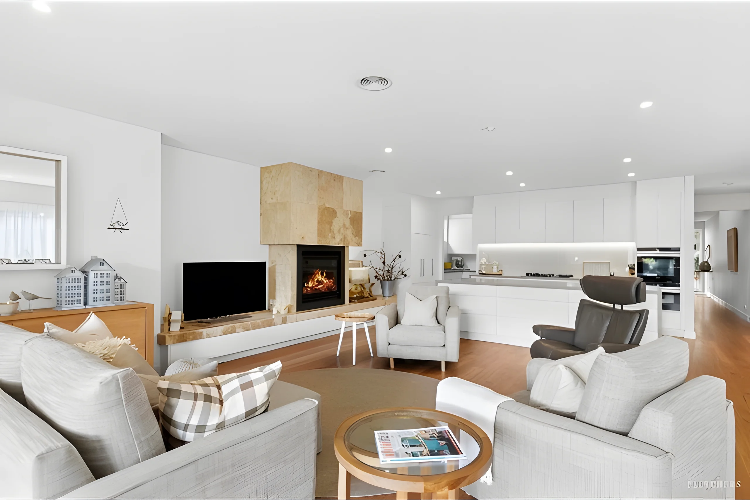 King Street Townhouse B living room with a stone fireplace and white kitchen